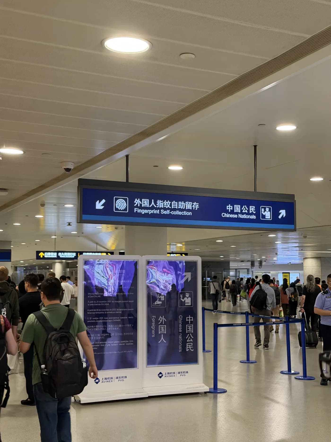 Hinweisschild im Ankunftsbereich des Flughafens Shanghai Pudong mit der Aufschrift Fingerprint Self-collection für Ausländer und einem separaten Weg für chinesische Staatsbürger