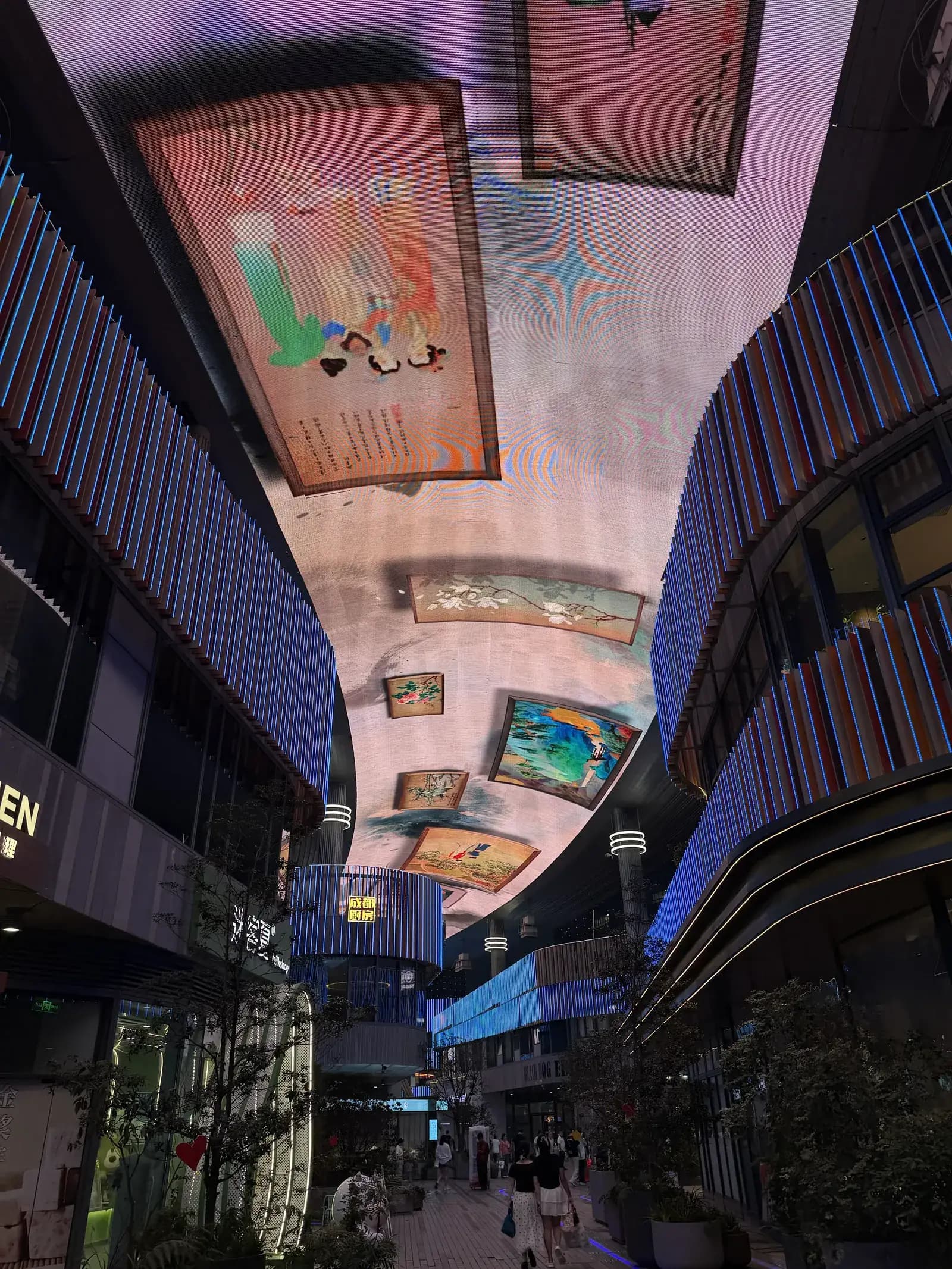 Gasse zwischen Geschäften, überspannt von einer großen LED-Decke mit Motiven im Stil chinesischer Malerei