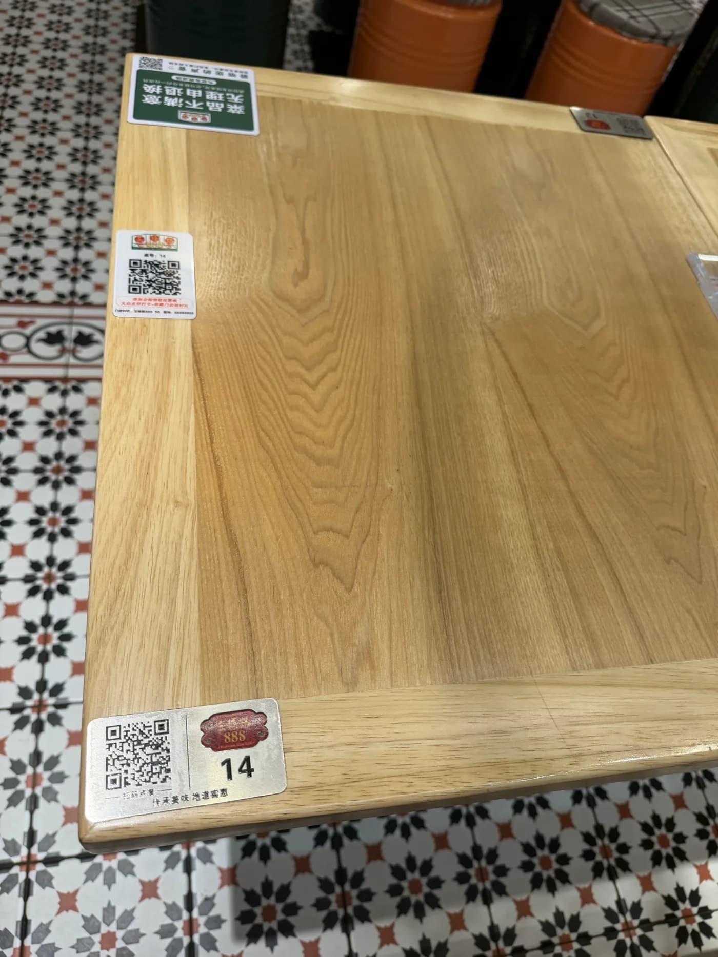 Restauranttisch in China mit mehreren aufgeklebten QR-Code-Stickern, einer davon mit der Tischnummer 14