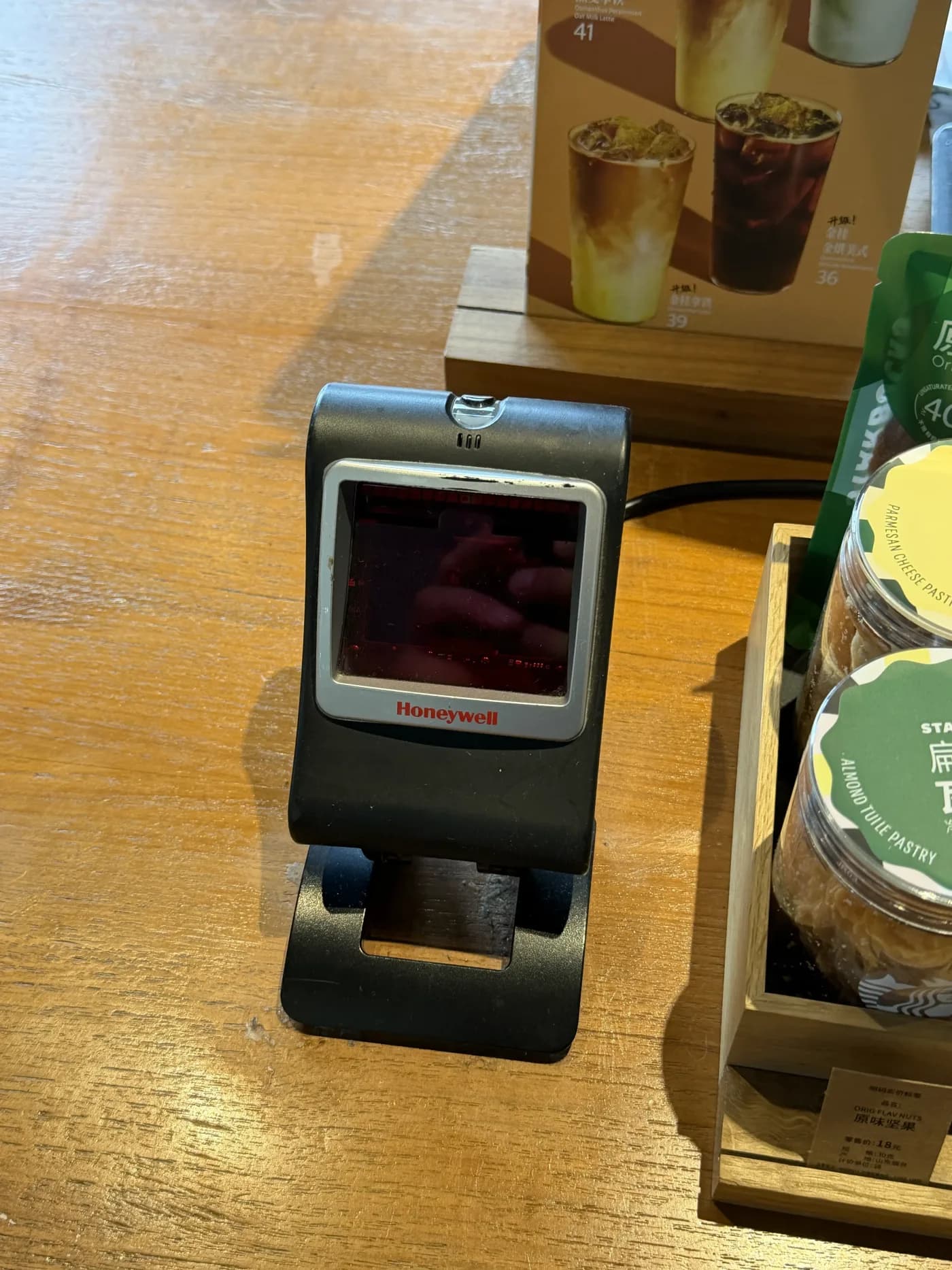 Barcode-Scanner auf einer Ladentheke in China, daneben Gebäck und eine Getränkekarte
